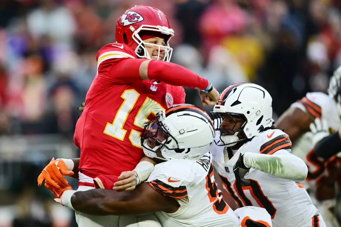 Cleveland Browns defensive tackle Mike Hall Jr. (No. 51) and linebacker Devin Bush (No. 30) converge on Kansas City Chiefs quarterback Patrick Mahomes during an NFL Week 15 game at Huntington Bank Field in Cleveland, Ohio on Sunday, Dec. 15, 2024.